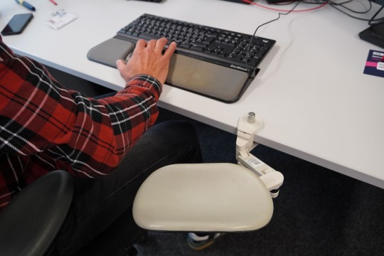 Die Bedienung einer Rollermaus mit einem Arm in Großaufnahme. Auch eine Armstütze ist zu sehen.