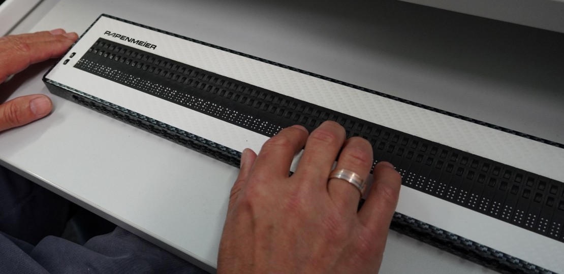 Eine Hand auf einer Braille-Zeile
