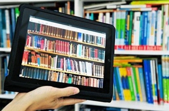Ein Tablet mit dem Bild eines Bücherregals wird vor ein reales Bücherregal gehalten